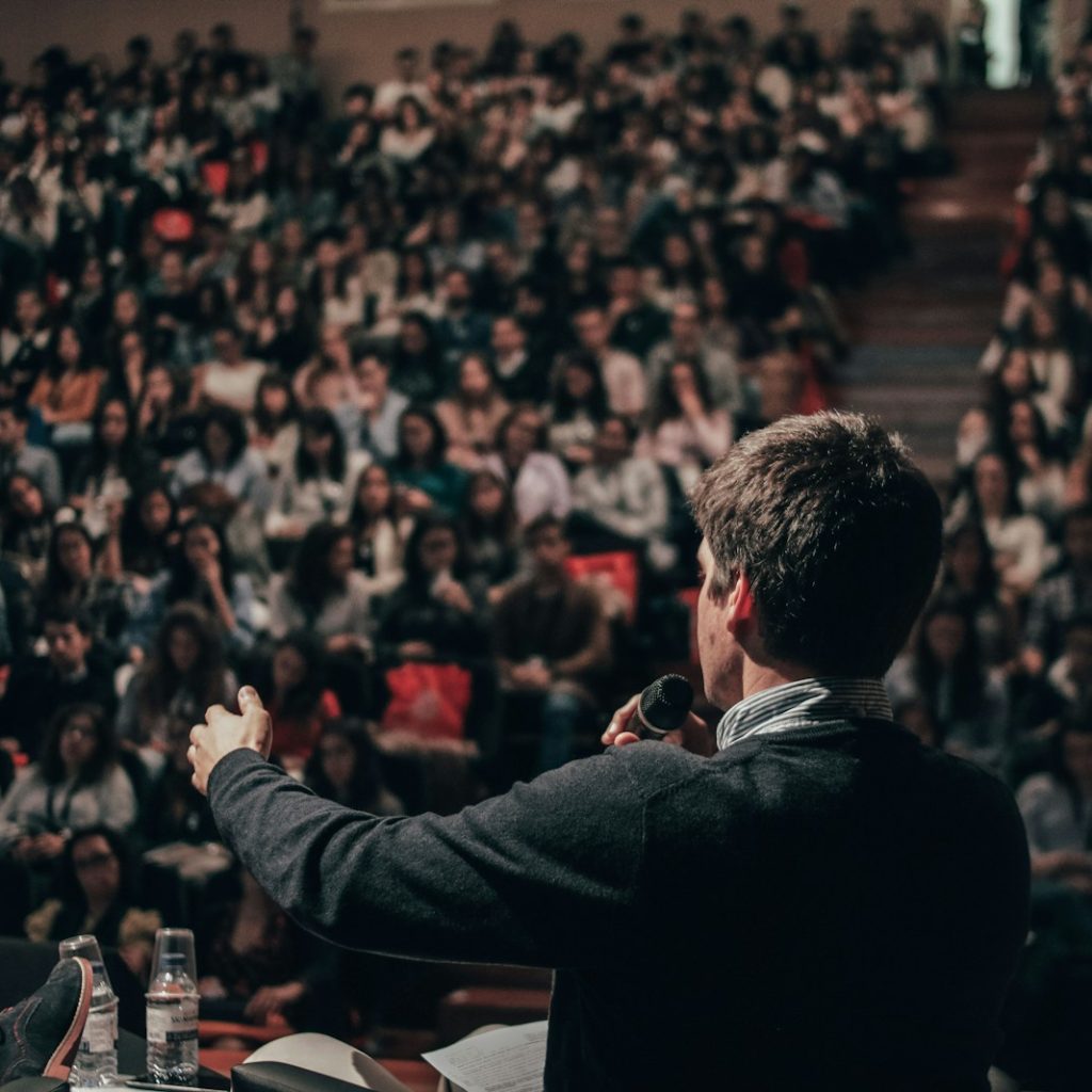 man speaking in front of crowd